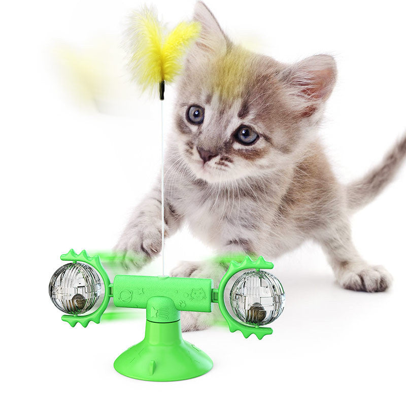 Cat playing with a green toy that resembles a double-sided light bulb