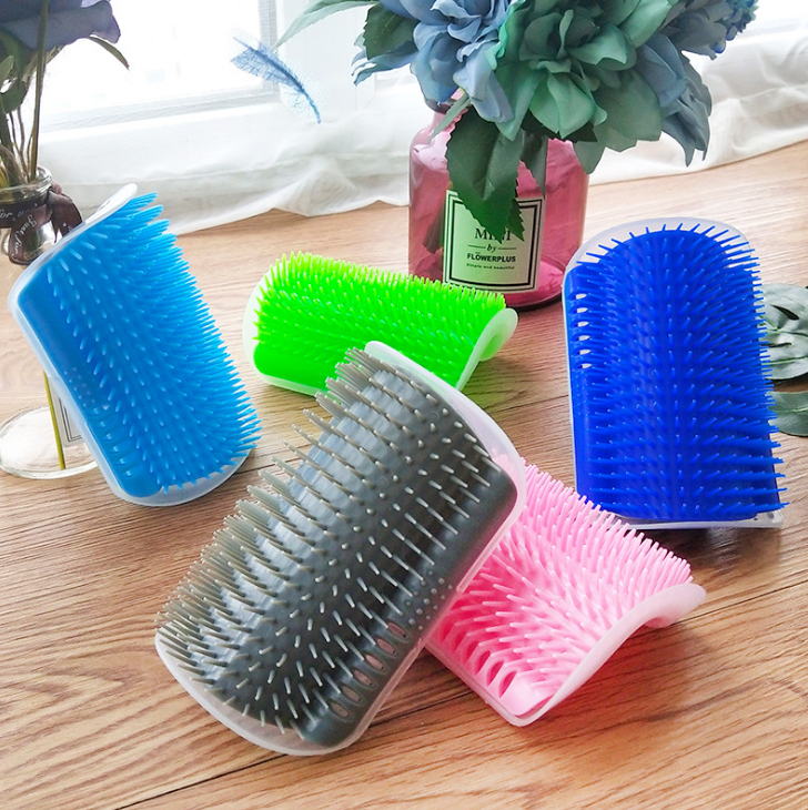 Set of colorful grooming brushes on a wooden surface with flowers in the background