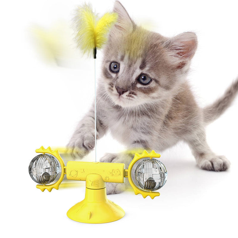 Cat playing with a yellow toy on a white background