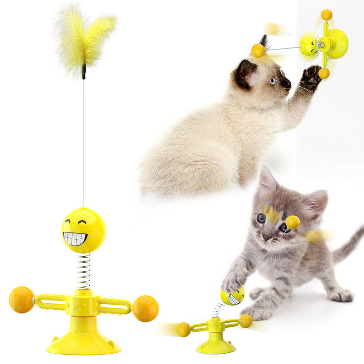 Cat playing with a yellow toy designed like a smiling face with a spring mechanism.