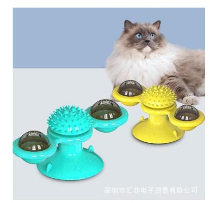 Cat playing with a colorful rotating toy on a light blue background