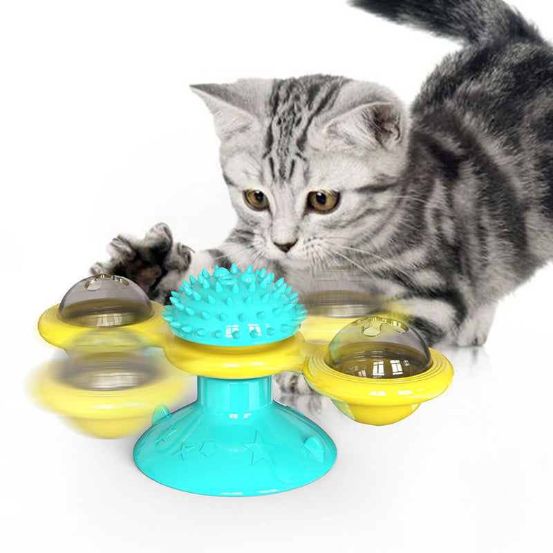 Cat playing with a colorful spinning toy on a white background