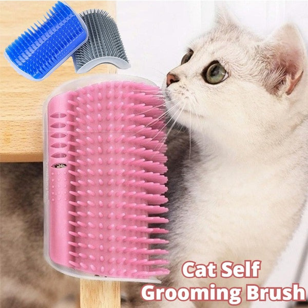 Cat self-grooming brush with pink bristles next to a cat on a wooden surface.